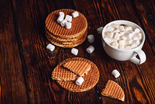 Stroopwafel with Broken One with White Cup of Cocoa with Marshmallow and Waffle Stack. Copy Space on the Left.
