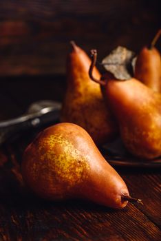 Few Golden Pears with Fork and Knife on Wooden Table. Vertical Orientation.