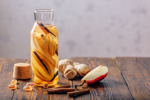 Bottle of Water with Sliced Pear, Cinnamon Stick, Ginger Root and Dark Sugar. Copy Space.