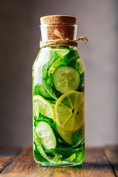 Cleansing Water Flavored with Sliced Lemon, Cucumber and Fresh Sprigs of Mint. Vertical Orientation.