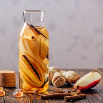 Bottle of Water with Sliced Pear, Cinnamon Stick, Ginger Root and Dark Sugar. Copy Space.