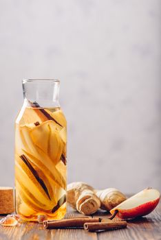Water infused with Pear, Ginger Root and Cinnamon Stick. Some Ingredients on Table. Vertical Orientation and Copy Space.