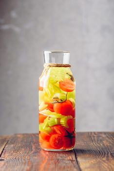 Water Flavored with Cherry Tomato and Celery Stems. Vertical Orientation.
