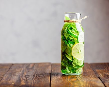 Detox Water Infused with Sliced Lemon, Cucumber and Fresh Sprigs of Mint. Copy Space on the Left.