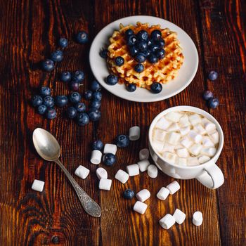 Waffles with Fresh Blueberry and Honey on Plate, Cup of Coffee with Marshmallow.