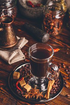 Cup of Coffee with Oriental Spices on Metal Tray. Cezve and Some Jars on Background.