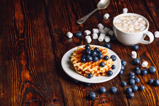 Waffles with Fresh Blueberry and Honey on Plate, Cup of Coffee with Marshmallow. Copy space on the Left Side.