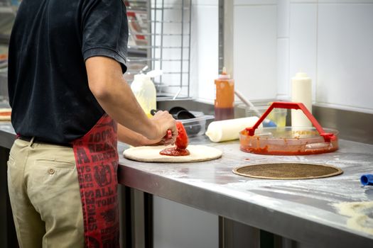 Cooking dough by the hands of men in a pizza restaurant