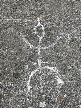 Close up view of petroglyph man carved in stone in Karelia, Russia