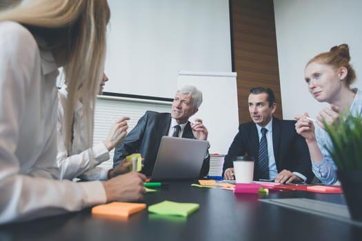 Working process at business meeting , people sitting around office table discussing ideas