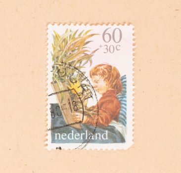 THE NETHERLANDS 1980: A stamp printed in the Netherlands shows a child and a frog with a crown, circa 1980