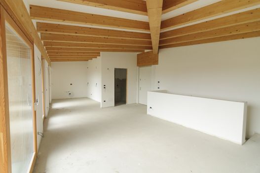 Building site or home renovation in progress: empty open space with large windows and exposed wooden beams