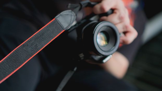 Young man photographer holds camera. Photographer concept. Blurred background for banner