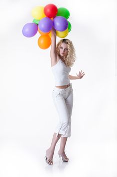 Young blonde beautiful woman in fashionable clothing with coloured balloons