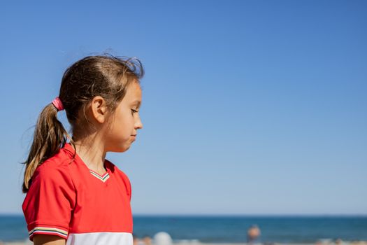 Little girl posing on the beach with the Mediterranean Sea in the background