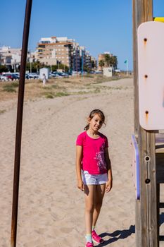 Little girl playing in a playground on the beach