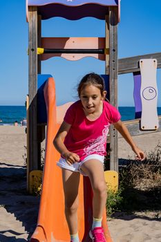 Little girl playing in a playground on the beach