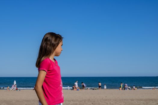 Little girl posing on the beach with the Mediterranean Sea in the background
