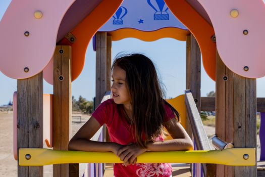 Little girl playing in a playground on the beach
