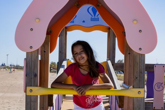 Little girl playing in a playground on the beach