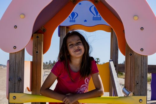 Little girl playing in a playground on the beach