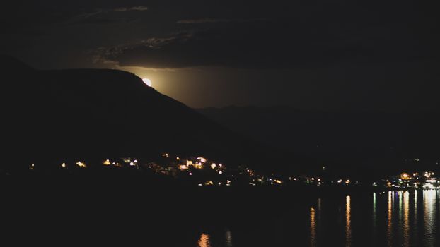 The Moon is coming out of the mountain. Dark tones