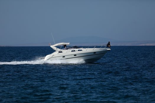 Small launch boat with people, blue sea and sky