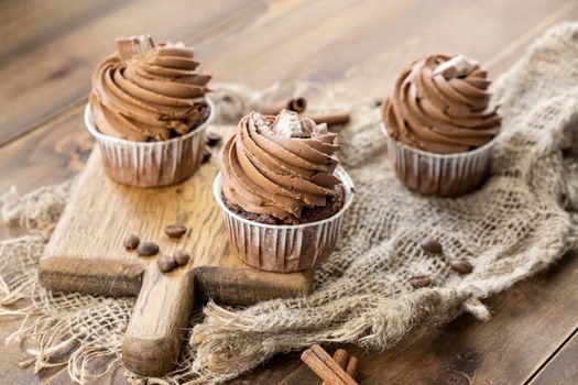 brown cupcakes with cocoa cream, cinnamon and coffee