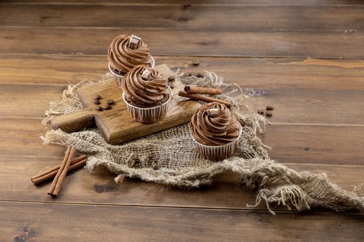 brown cupcakes with cocoa cream, cinnamon and coffee