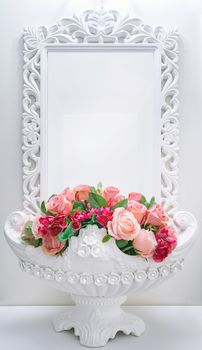 Flower pot with artificial roses on a background of a mirror