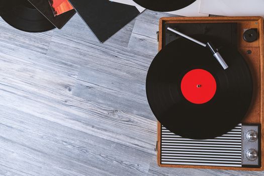 Turntable vinyl record player on the background of their gray wooden boards. Needle on a vinyl record. Black vinyl record,Sound technology for DJ to mix & play music.