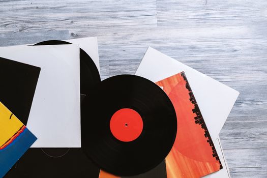 Black vinyl record and covers album on the background of their gray wooden boards.Vintage style with copy space.