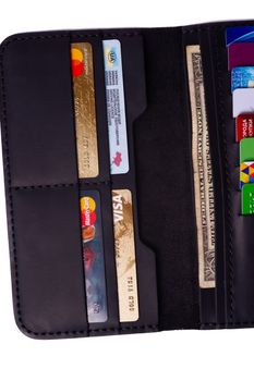 24.01.2019 Ukraine, Kyiv. A part of handmade black leather wallet isolated on white background closeup. A lot of plastic cards in purse pockets. Editorial use only.