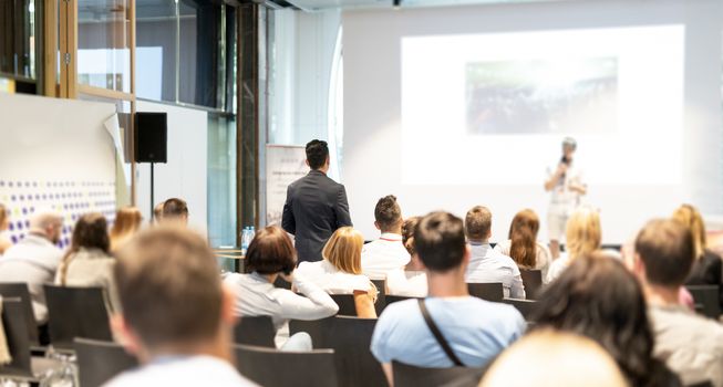 I have a question. Group of business people in conference hall. Businessman in audience standing and asking question to speeker. Conference and Presentation. Business and Entrepreneurship.