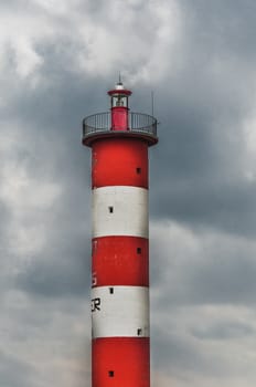 Lighthouse of Port-La-Nouvelle in red and white on cloudy sky in Occitanie, France