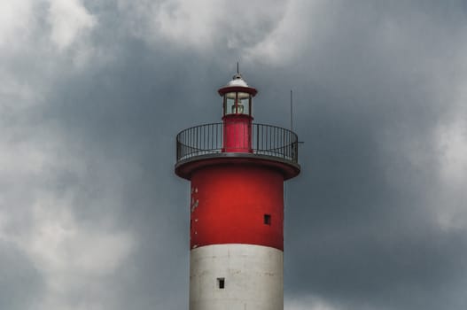 Lighthouse of Port-La-Nouvelle in red and white on cloudy sky in Occitanie, France