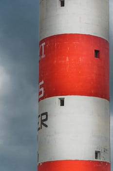 Lighthouse of Port-La-Nouvelle in red and white on cloudy sky in Occitanie, France