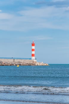 Lighthouse of Port-La-Nouvelle in red and white on cloudy sky in Occitanie, France