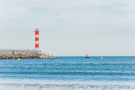 Lighthouse of Port-La-Nouvelle in red and white on cloudy sky in Occitanie, France