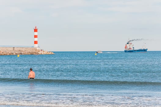 Lighthouse of Port-La-Nouvelle in red and white on cloudy sky in Occitanie, France