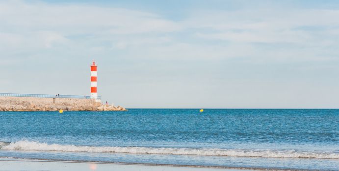 Lighthouse of Port-La-Nouvelle in red and white on cloudy sky in Occitanie, France