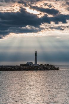 Lighthouse of Port-La-Nouvelle in red and white on cloudy sky in Occitanie, France