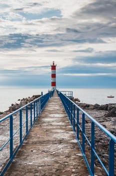 Lighthouse of Port-La-Nouvelle in red and white on cloudy sky in Occitanie, France