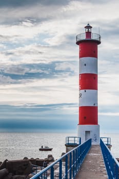 Lighthouse of Port-La-Nouvelle in red and white on cloudy sky in Occitanie, France