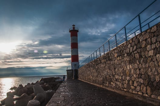 Lighthouse of Port-La-Nouvelle in red and white on cloudy sky in Occitanie, France