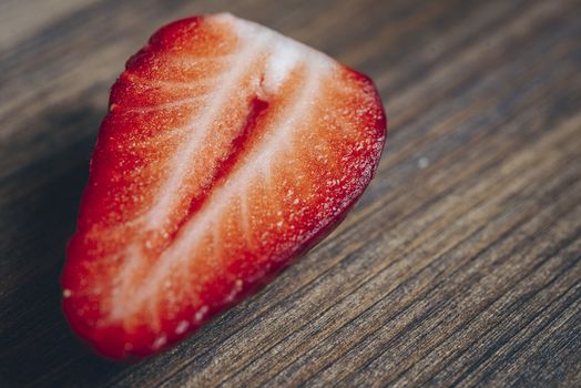 half strawberry on a wooden background in rustic style, copy space for text