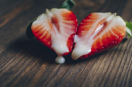 metaphor of sex with strawberries and milk in a wooden background, top view, copy space for text