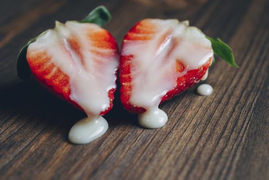 metaphor of sex with strawberries and milk in a wooden table, top view, copy space for text