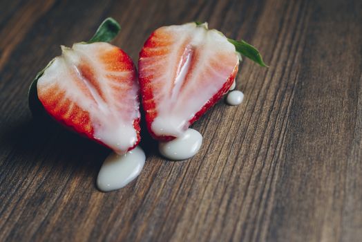 metaphor of sex with strawberries and milk on a purple wooden background, top view, copy space for text