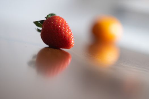 Baby exploring some fruits with his hand on a dark wooden table